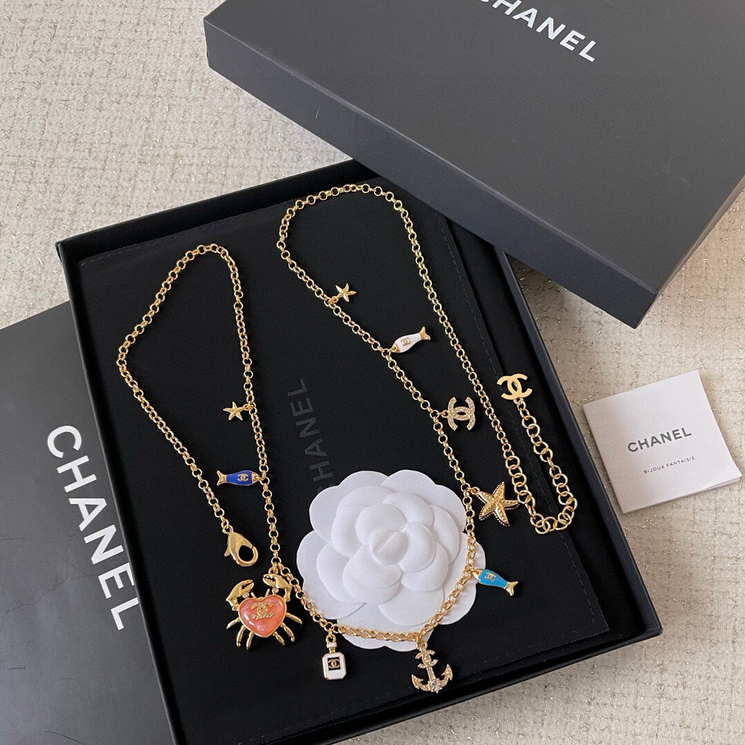 MULTI-CHARM CHAIN BELT IN GOLD METAL CRYSTAL DOUBLE C PENDANT AND OCEAN MOTIFS